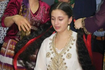 Perty cries during the wedding ceremony Young girl cries as an older woman unravels her hair, sympbolising the end of maidenhood.
