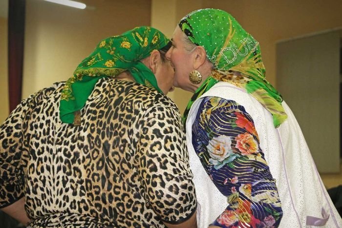 Gypsy women Two older gypsy women wearing head scarves whisper into each other's ears.