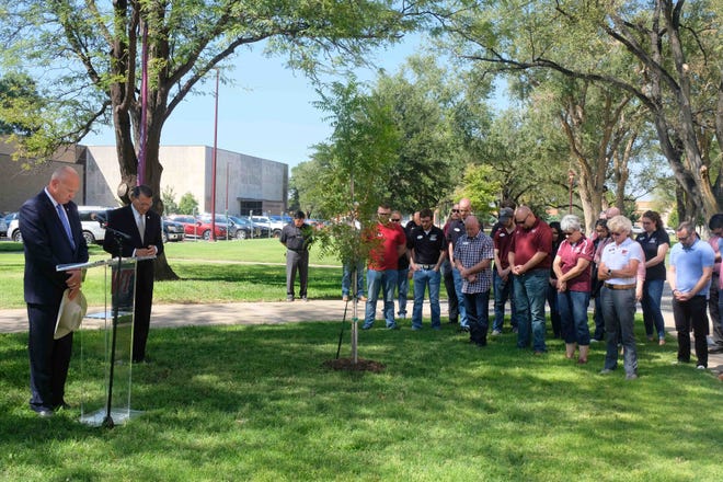 West Texas A&M University officials and attendees hold a moment of silence in honor of Queen Elizabeth II at a Queen's Canopy initiative tree planting on campus in Canyon.