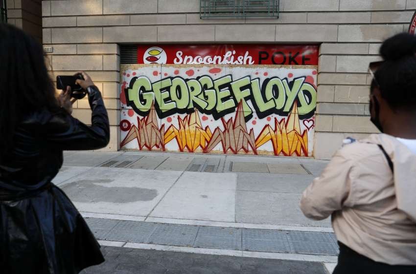 Protesters take a photograph graffiti with the name of George Floyd along S. 3rd St. in downtown San Jose, Calif., on Monday, June 1.