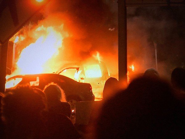 A vehicle engulfed in flames in front of La Mesa City Hal...