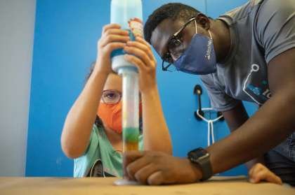Gabrielle Griffing, 8, works with teacher Abdoulaye Traore to create a density column during a STEAM summer camp class, Tuesday, July 14, 2020, at IDEA Lab Kids in Bellaire. The business has put numerous protocols into place to try and prevent the spread of COVID-19 between kids, parents and teachers. Check-in each morning happens outside of the business, and temperature checks are made daily as well as requiring masks among the older children and all adults.