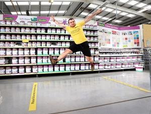 Woodies team member Ryan Cromwell  tries to jump over the 2 meter distancing stencil on the floor at the Woodies.