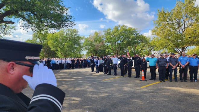 First responders salute two fallen firefighters, Dalhart Fire Chief Curtis Brown and volunteer firefighter Brendan Torres, at a service in October in Dalhart.