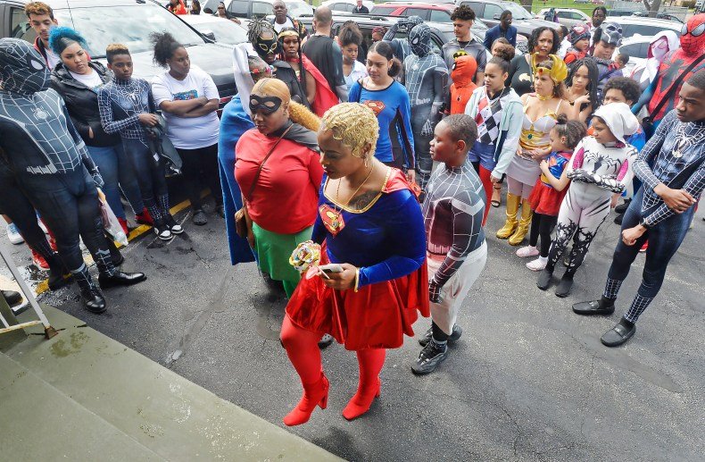 Raquel Coleman, center, mother of seven-year-old homicide victim Antonio Yarger Jr., leads mourners into the funeral service for her son inside Second Baptist Church in Erie on April 23, 2022. Antonio was shot in the head while walking in his neighborhood with a group of friends on April 14, and died four days later from his injuries. The family requested mourners wear superhero costumes in honor of Antonio, who was a fan of Spiderman.