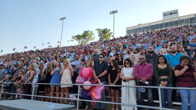 The Canyon High School graduation crowd stands for a moment of silence to show respect for the victims of the Uvalde, Texas School shooting during the commencement ceremony at Happy State Bank Stadium.