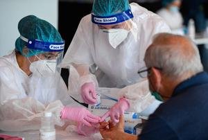 A man is tested for the novel coronavirus COVID-19 at the National Arena stadium in Bucharest. (Photo by DANIEL MIHAILESCU/AFP via Getty Images)