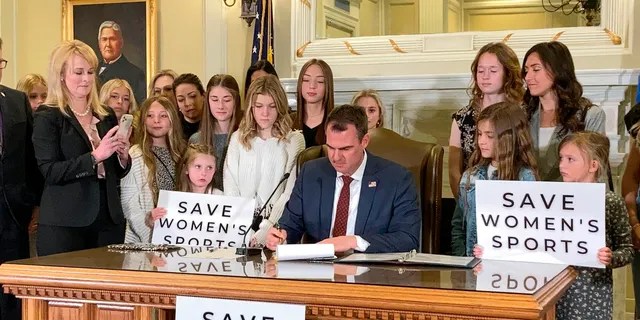 FILE - In this March 30, 2022 file photo Oklahoma Gov. Kevin Stitt signs a bill in Oklahoma City that prevents transgender girls and women from competing on female sports teams. 