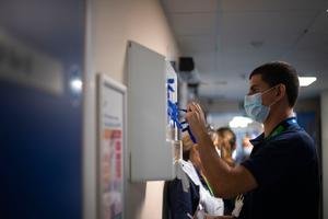 A support worker puts on PPE as the first patients are admitted to the NHS Seacole Centre at Headley Court, Surrey, a disused military hospital, which has been converted during the coronavirus pandemic. Photo: Victoria Jones/PA Wire