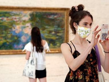 Libby Krueger of Fort Worth takes a photo of paintings in the Kimball Art Museum as her friend Kimberly Brubacher of Los Angeles views Claude Monet's Water-Lily Pond (1917-19) in Fort Worth, Tuesday, July 14, 2020. (Tom Fox/The Dallas Morning News)