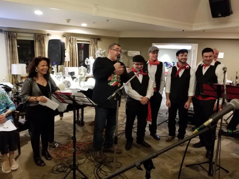 Pat Mostacci joins a traditional Italian music group to sing for residents of Villa Italia during a Christmas party in 2018.